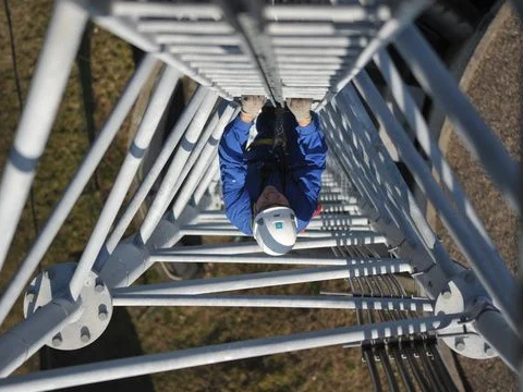 Un technicien Bouygues Telecom qui gravit un pylône