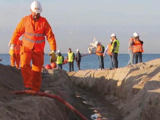 Des techniciens Orange sur un chantier d’atterrissement de câble, en bord de mer