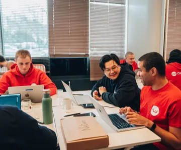 Collaborateurs Netwo qui rient autour d’une table de travail